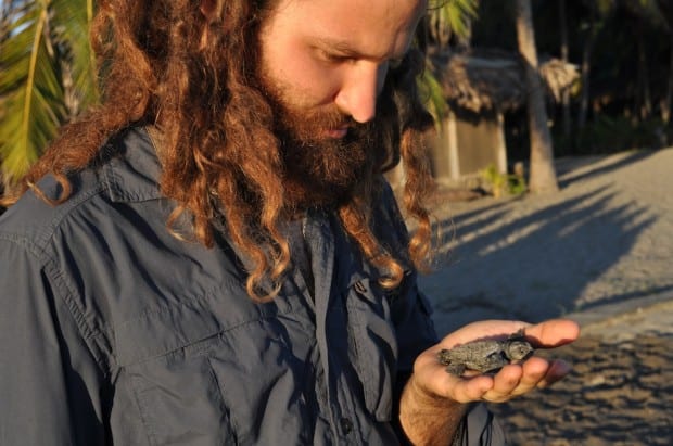 Aaron contemplates his connection to a new baby turtle.